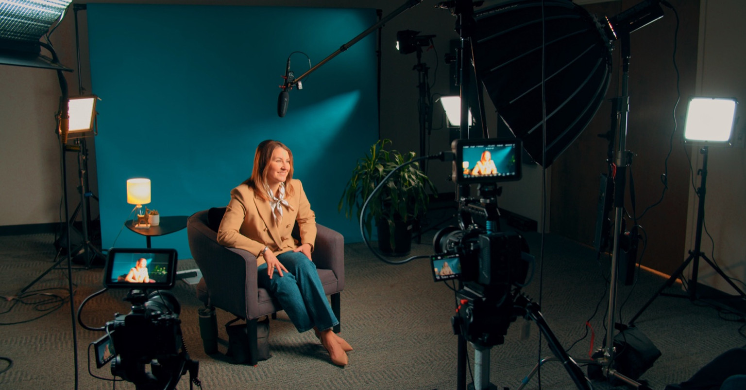 Behind the scenes of a live-action shoot in Lemonly's video studio, with cameras, lights, and a boom mic around the interview chair